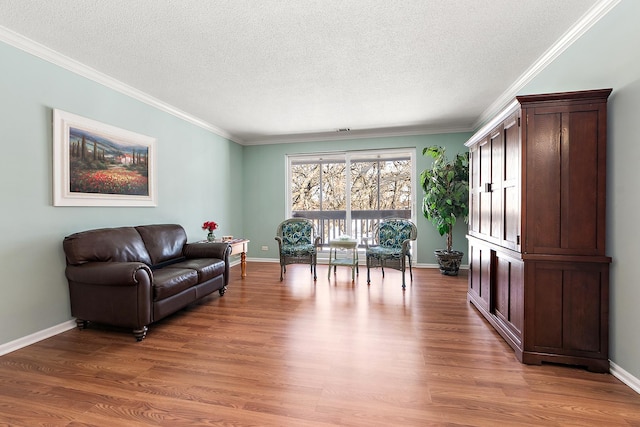 living area featuring ornamental molding, wood finished floors, and baseboards