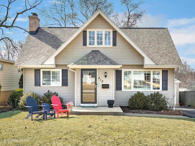 view of front of property with a front lawn, a chimney, and a shingled roof