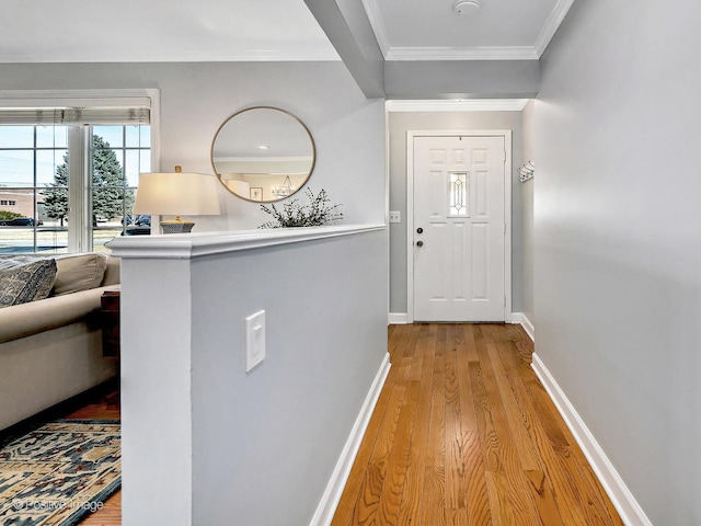 hall with crown molding, wood finished floors, and baseboards