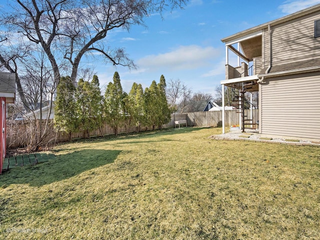 view of yard with a fenced backyard and stairs