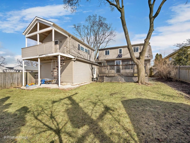 back of property with a yard, a deck, and a fenced backyard