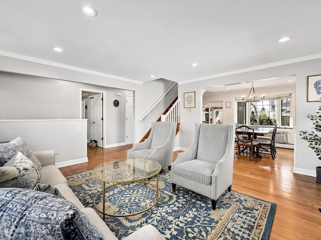 living room featuring crown molding, baseboards, stairway, an inviting chandelier, and wood finished floors