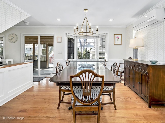 dining area featuring crown molding, a chandelier, a wall mounted air conditioner, a wealth of natural light, and light wood-style floors