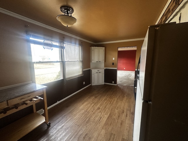 interior space featuring baseboards, ornamental molding, and dark wood finished floors