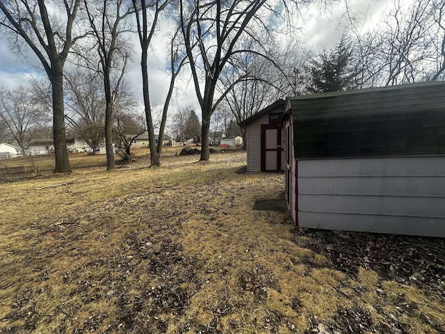 view of yard featuring a storage shed and an outbuilding