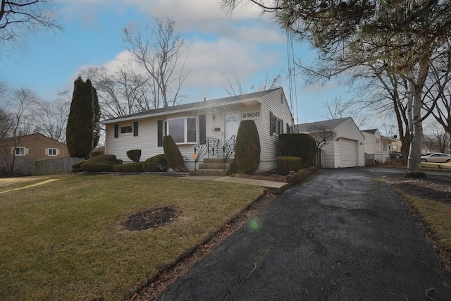 view of front of home with aphalt driveway, fence, and a front lawn