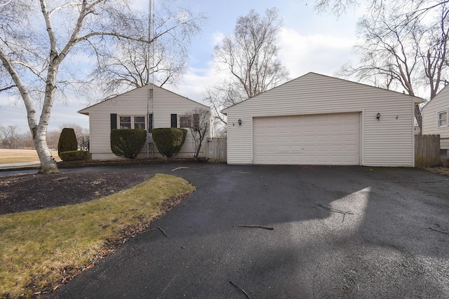 view of front of house featuring an outbuilding, fence, and a garage