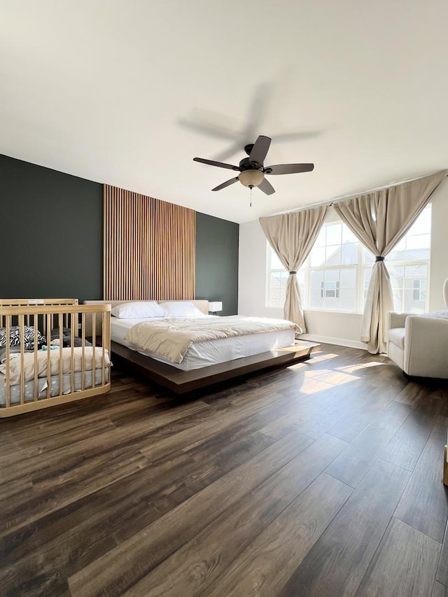 unfurnished bedroom featuring wood finished floors, a ceiling fan, and baseboards