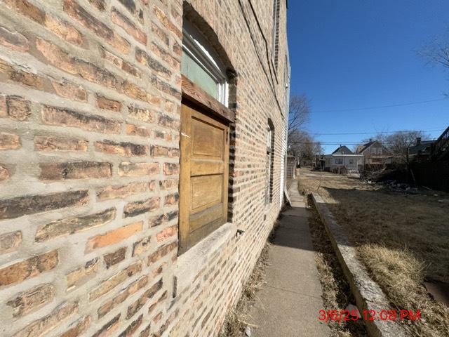 view of side of home with brick siding