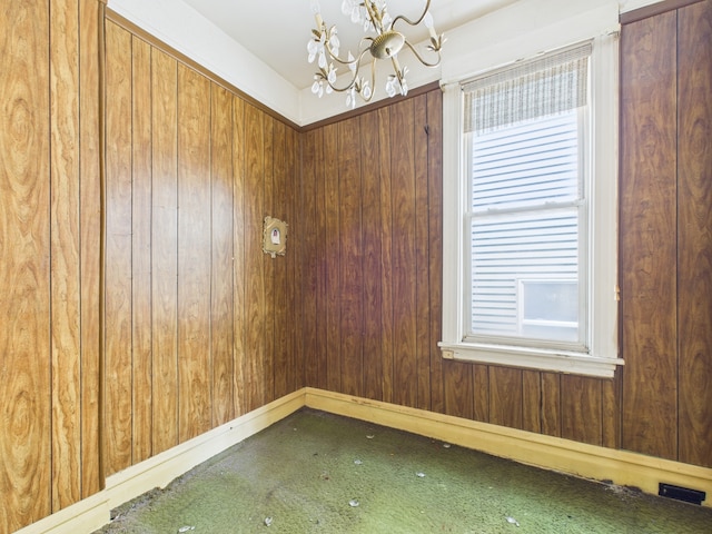 6725 S Justine St, Chicago, IL 60636 - carpeted empty room featuring a chandelier and wood walls