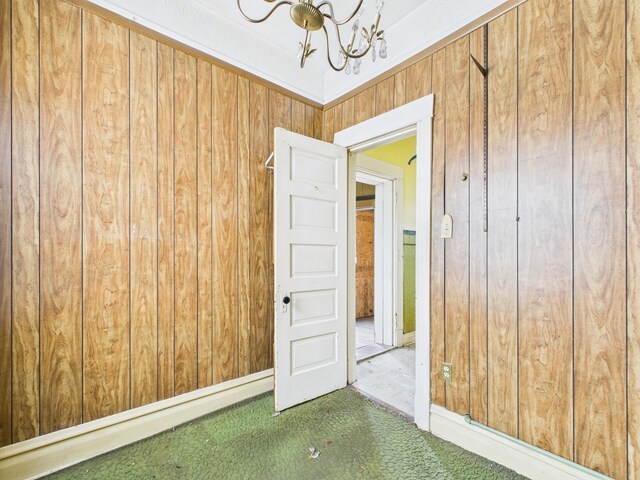 6725 S Justine St, Chicago, IL 60636 - carpeted empty room featuring a chandelier and wood walls