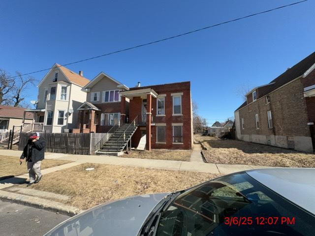 view of front of house with a residential view and fence