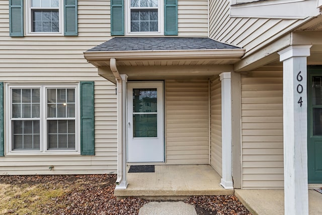 entrance to property featuring a shingled roof