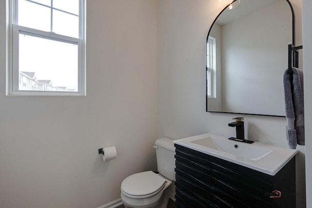 bathroom featuring toilet, a healthy amount of sunlight, and vanity