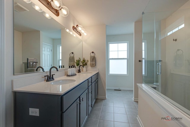 full bathroom with tile patterned flooring, a shower stall, visible vents, and a sink