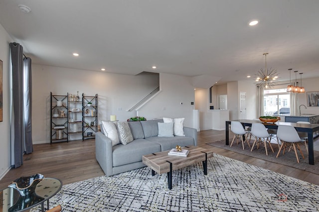 living area featuring recessed lighting, a chandelier, baseboards, and wood finished floors