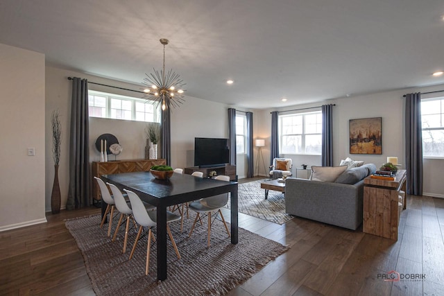 dining space featuring hardwood / wood-style flooring, a notable chandelier, recessed lighting, and baseboards