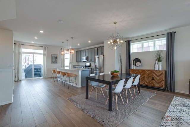 dining space with a wealth of natural light, a chandelier, light wood-style flooring, and recessed lighting