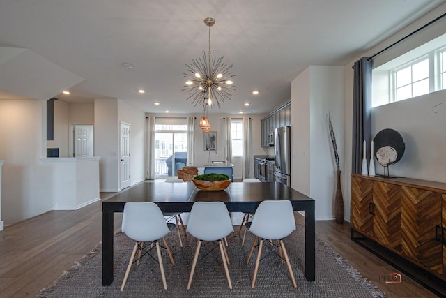 dining space with a notable chandelier, wood finished floors, recessed lighting, and baseboards