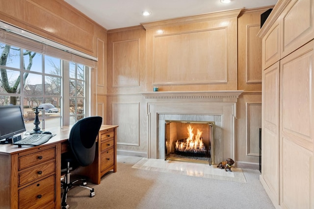 office space featuring a fireplace with flush hearth, ornamental molding, recessed lighting, a decorative wall, and light colored carpet