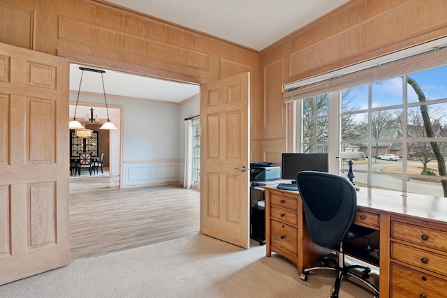 office space featuring light carpet, a decorative wall, and crown molding