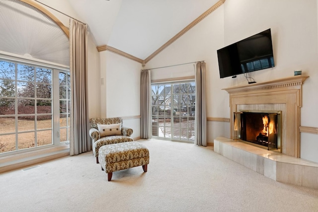 living area featuring visible vents, high vaulted ceiling, carpet flooring, and a tiled fireplace