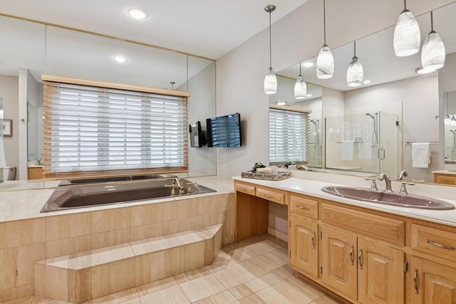 bathroom with a shower stall, vanity, and a garden tub