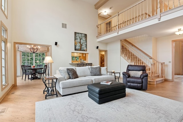 living room featuring stairs, wood finished floors, visible vents, and a chandelier