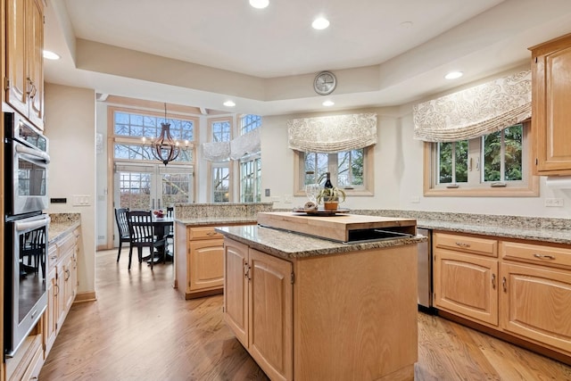 kitchen with light brown cabinetry, light wood-style flooring, and a center island