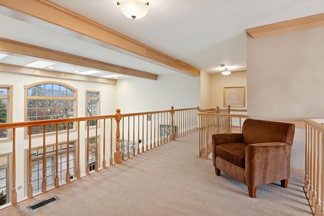 living area featuring beam ceiling, carpet flooring, and visible vents