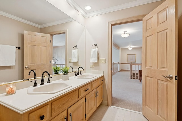 bathroom featuring double vanity, crown molding, and a sink