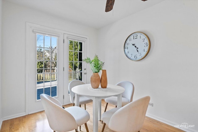 dining area featuring a ceiling fan, baseboards, and light wood-type flooring