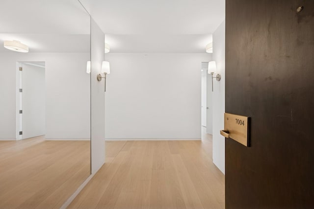 hallway with baseboards and light wood finished floors