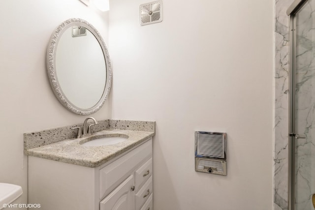 bathroom with heating unit, visible vents, toilet, and vanity