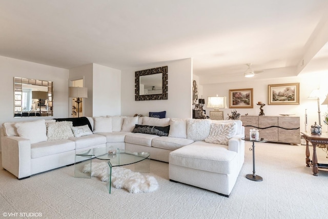 living room featuring a ceiling fan and carpet