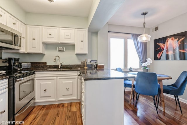 kitchen featuring visible vents, appliances with stainless steel finishes, a peninsula, and white cabinetry