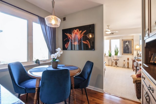 dining space featuring visible vents, baseboards, and wood finished floors