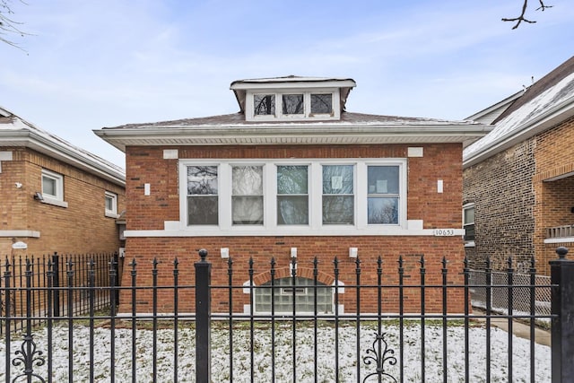 view of front of home with a fenced front yard and brick siding