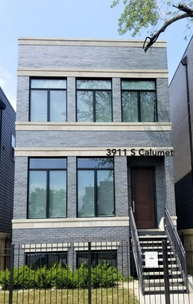 view of front of property featuring a fenced front yard and brick siding