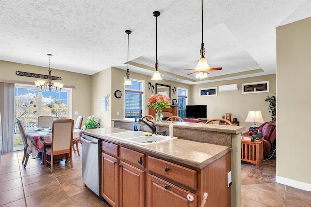 kitchen with a sink, dishwasher, a textured ceiling, a raised ceiling, and a kitchen island with sink