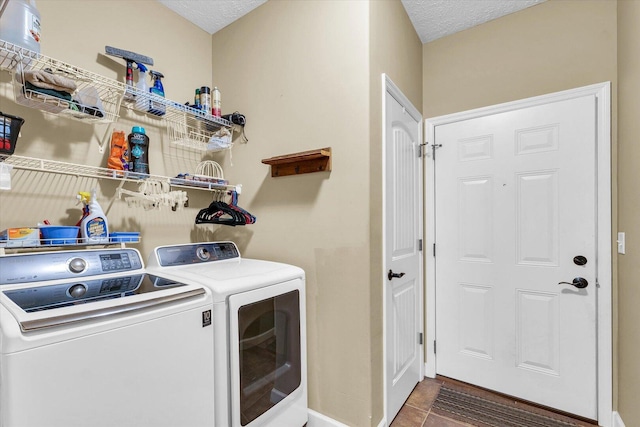 laundry room with a textured ceiling, washing machine and dryer, and laundry area