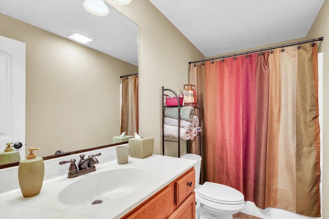 bathroom with a textured ceiling, vanity, and toilet