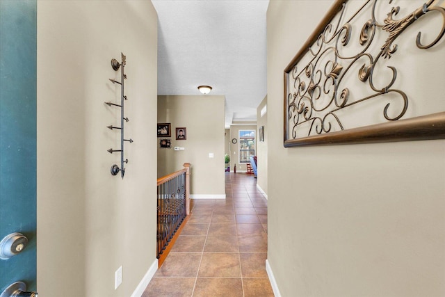 corridor featuring tile patterned floors and baseboards