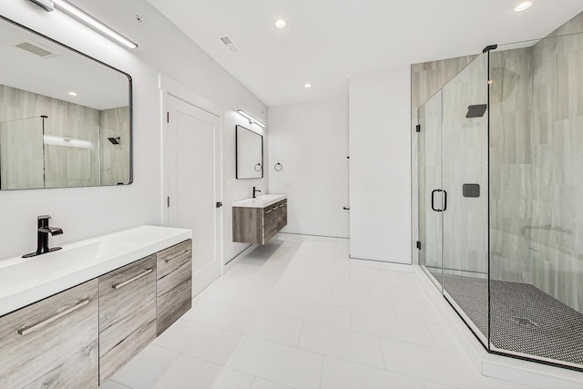 bathroom featuring visible vents, a shower stall, two vanities, recessed lighting, and a sink