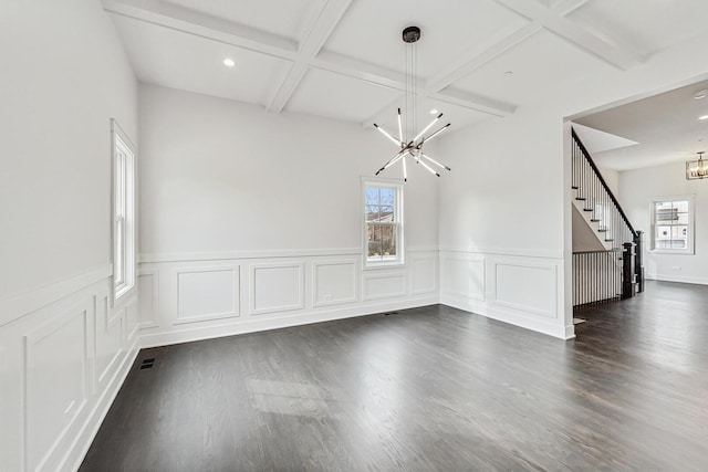 interior space featuring stairway, coffered ceiling, dark wood finished floors, beam ceiling, and a chandelier