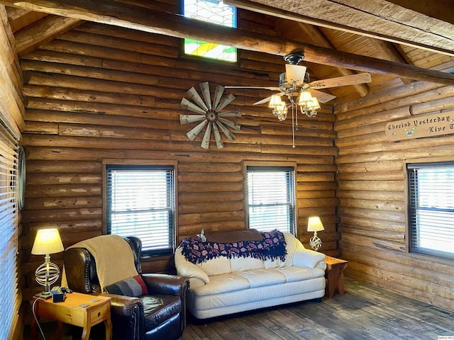 living room featuring wood-type flooring, plenty of natural light, log walls, and a towering ceiling