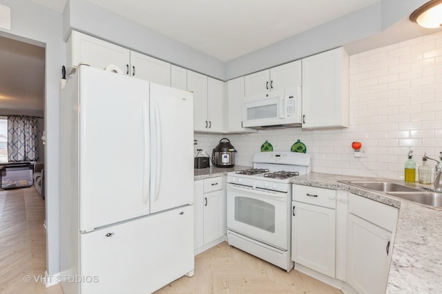 kitchen with white appliances, backsplash, a sink, and light countertops