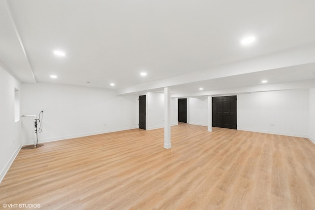 finished below grade area featuring baseboards, light wood-style flooring, and recessed lighting