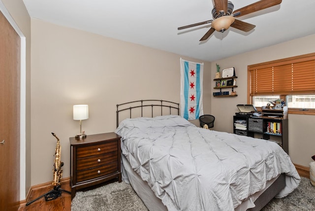 bedroom featuring wood finished floors, baseboards, and ceiling fan