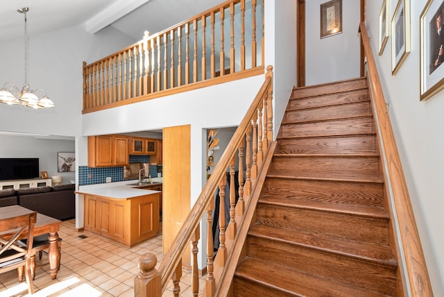 stairway with tile patterned flooring, an inviting chandelier, high vaulted ceiling, and beam ceiling